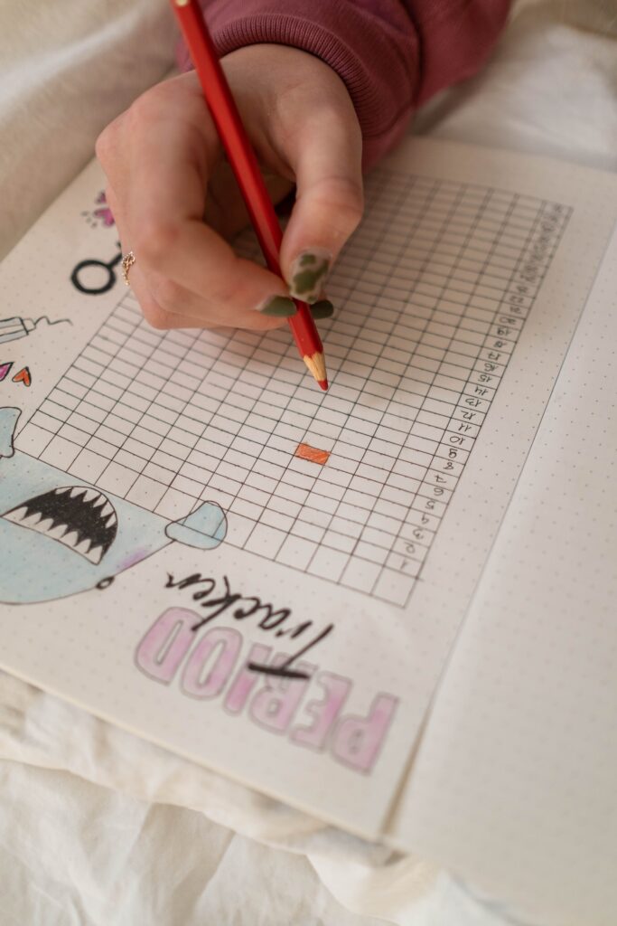 A woman in her early 40s looking at a calendar, tracking her monthly cycle